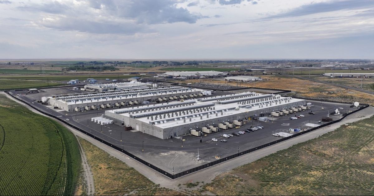 Aerial view of a large industrial data center campus surrounded by open land.