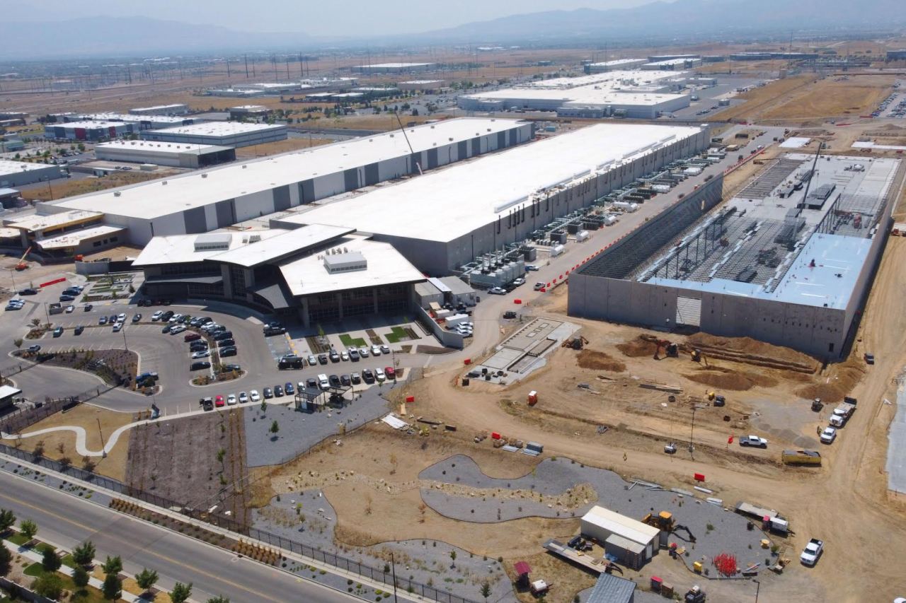 Aerial view of a very large data center facility with extensive buildings, parking, and utility infrastructure.